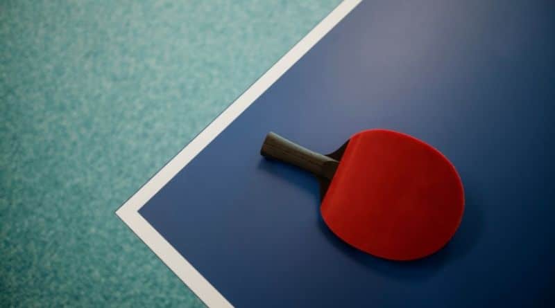 Tischtennisschläger auf einer blauen Tischtennisplatte