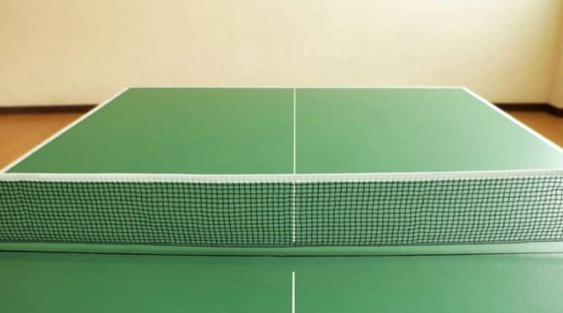 Eine grüne Tischtennisplatte steht aufgebaut in einem Raum